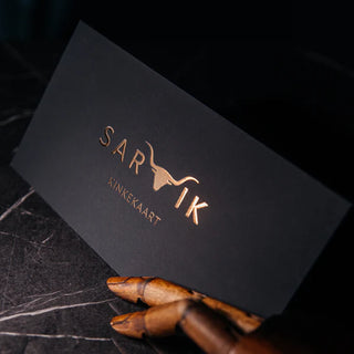 Premium gift card featuring matte soft touch lamination and raised gold foil logo, displayed with a wooden artist hand.