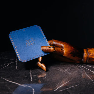 Blue luxury coaster featuring minimalist bronze foil printing and decorative borders.