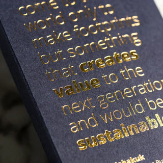 Premium gold foil embossed printing on dark textured cardstock featuring an inspirational quote about sustainability.