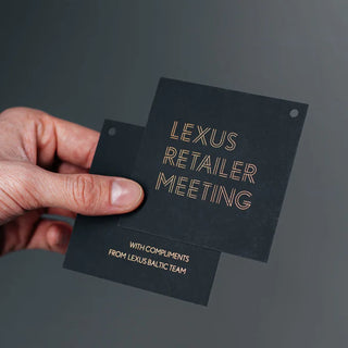 Elegantne must kutse või kaart kuldse trükiga, millel on tekst "LEXUS RETAILER MEETING". Allosas on väiksemas kirjas "WITH COMPLIMENTS FROM LEXUS BALTIC TEAM". Luksuslikult kujundatud materjal, mis on tõenäoliselt mõeldud Lexuse edasimüüjate või partnerite kohtumise jaoks. Kvaliteetsel tumedal paberil kuldne trükk loob premium-mulje, mis sobib hästi Lexuse luksusliku brändikuvandiga. | Trükikoda Brandcafe