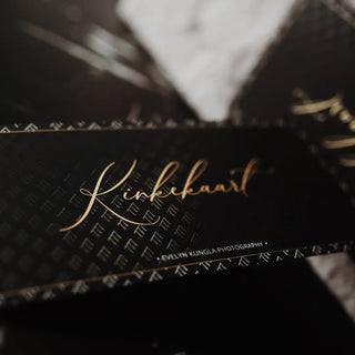 A close-up of a high-end, luxury black gift card featuring elegant screen print details and a gloss spot UV pattern over a gold script "Kinkekaart" design.