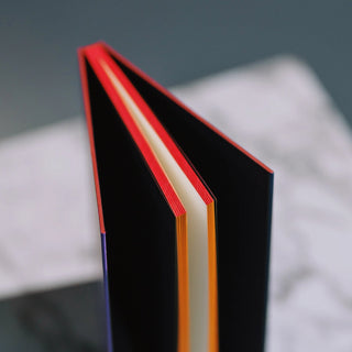 Luxury notebook manufacturers showcase custom red edge painting on premium black hardcover journals.