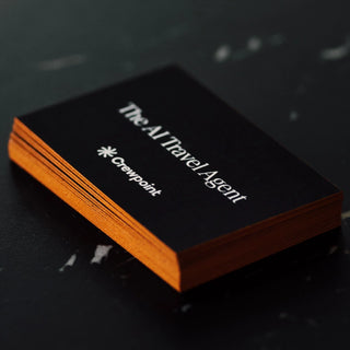 Premium black business cards featuring vibrant orange painted edges for Crewpoint The AI Travel Agent.