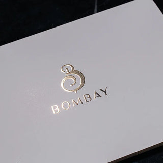 Elegant raised gold foil printing of the logo on a premium white card, showing the 3D texture and metallic shine.